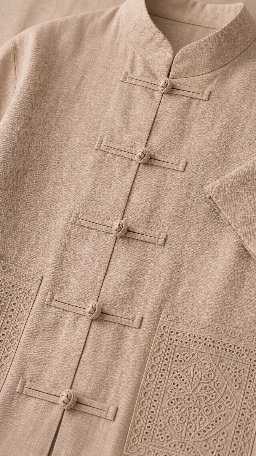 Close-up of taupe mandarin collar, knot frog buttons, and embroidered patch pocket