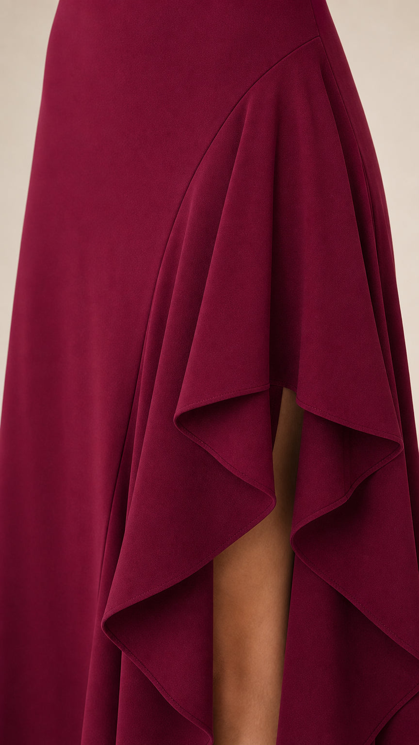 Close-up detail of the asymmetrical ruffle hem in burgundy