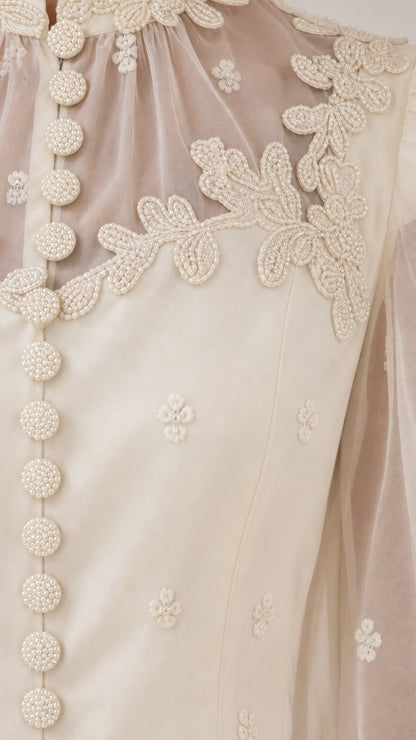 Close-up detail of lace embroidery and covered buttons on Ivory bodice