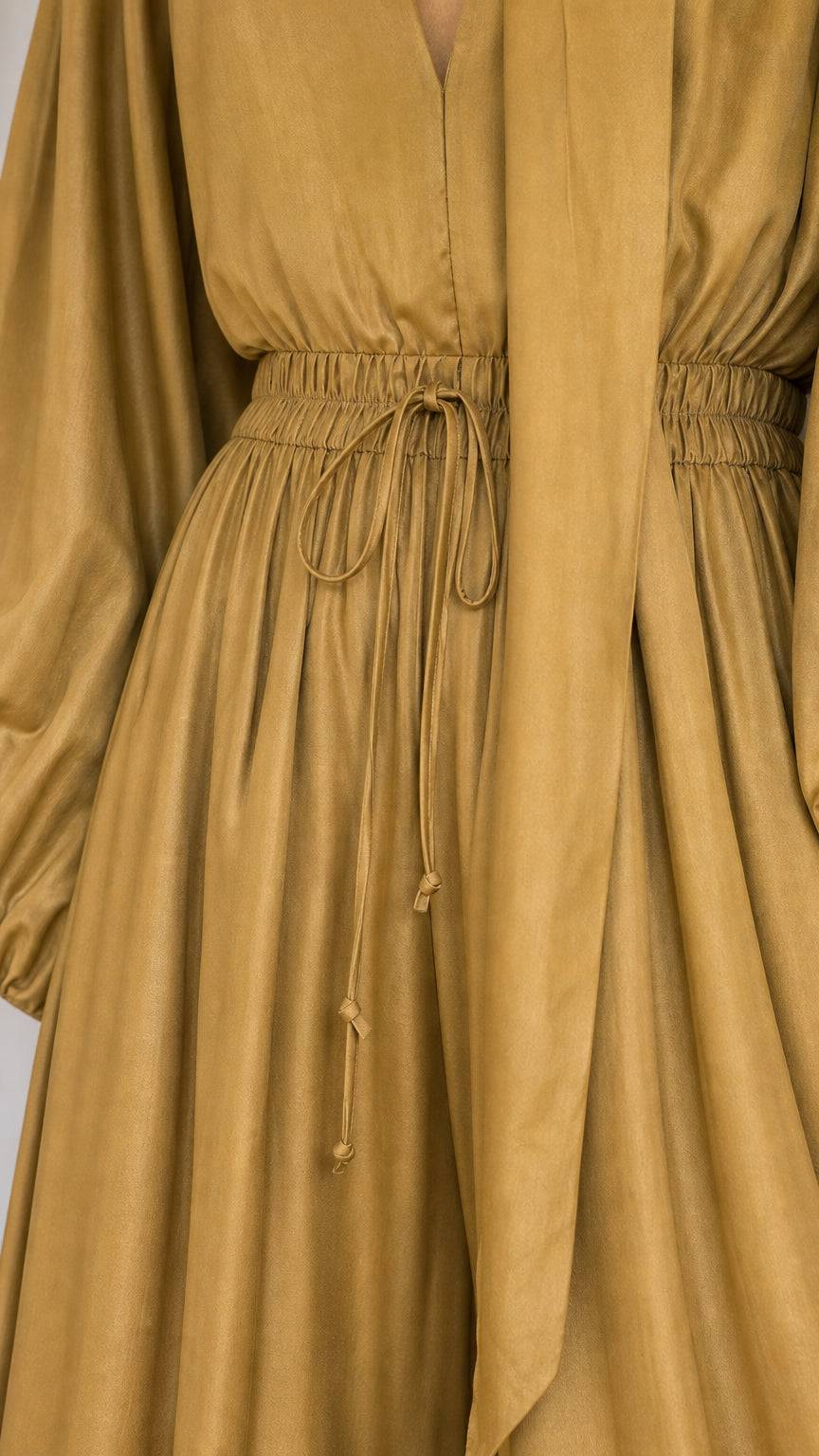 Close-up detail of mustard jumpsuit elastic drawstring waist and fabric texture