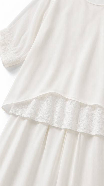 Close-up of white tunic hem with delicate lace trim