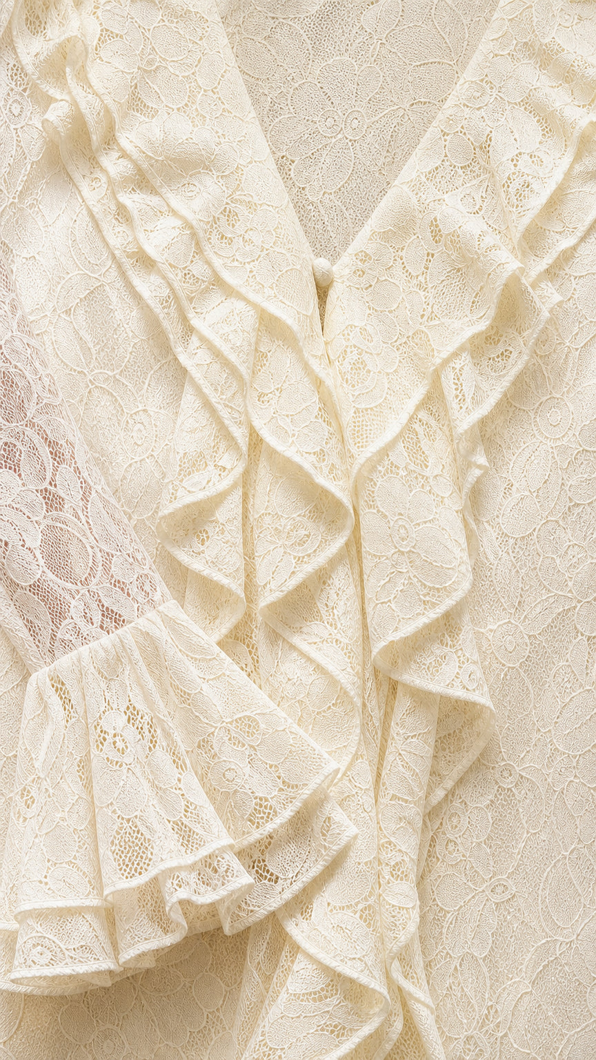 Close-up of V-neckline and ruffle details on ivory dress