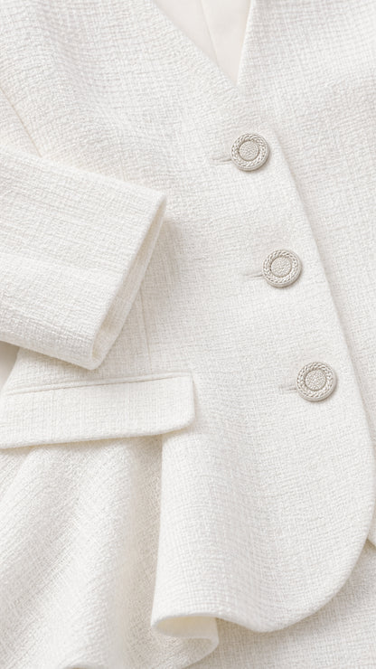 Close-up detail of textured woven white fabric and ornate round buttons