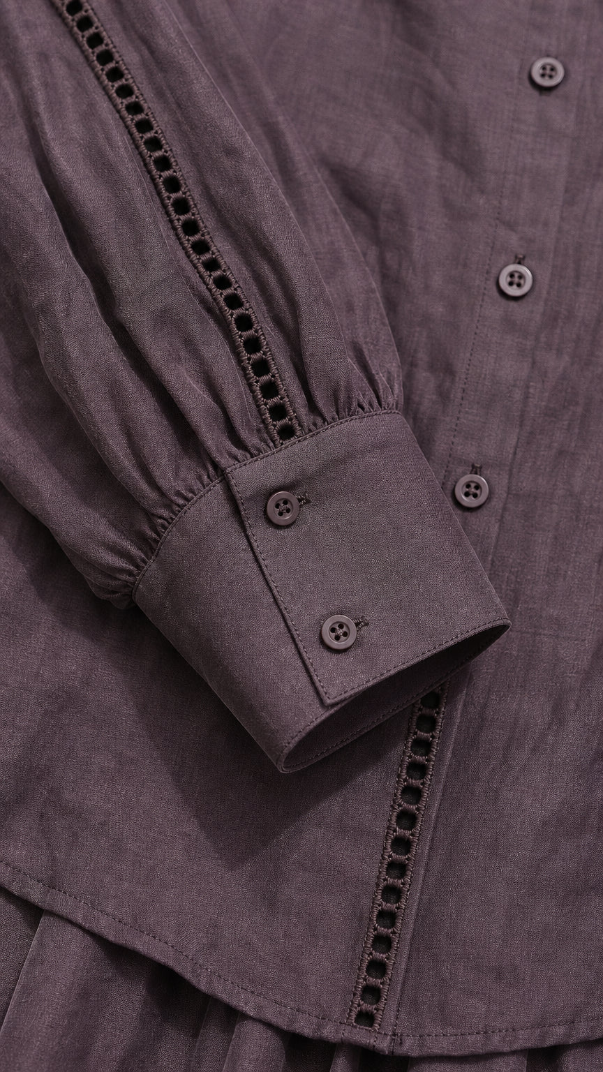 Close-up of blouse button front, decorative trim, and button cuff in mauve