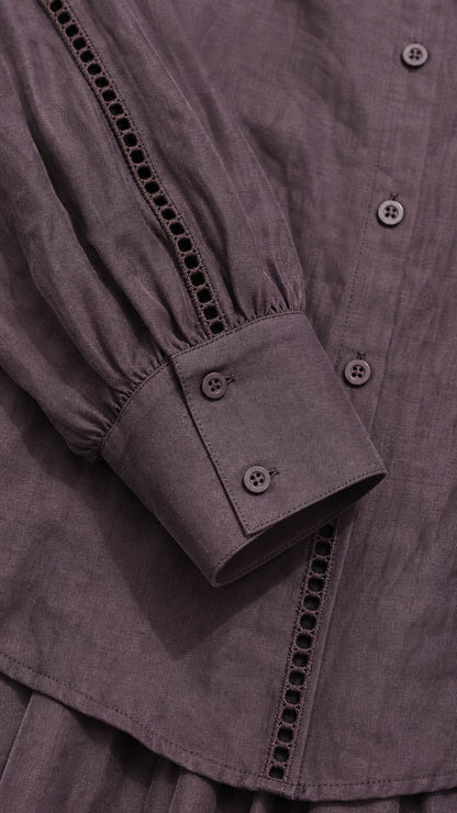Close-up of blouse button front, decorative trim, and button cuff in mauve