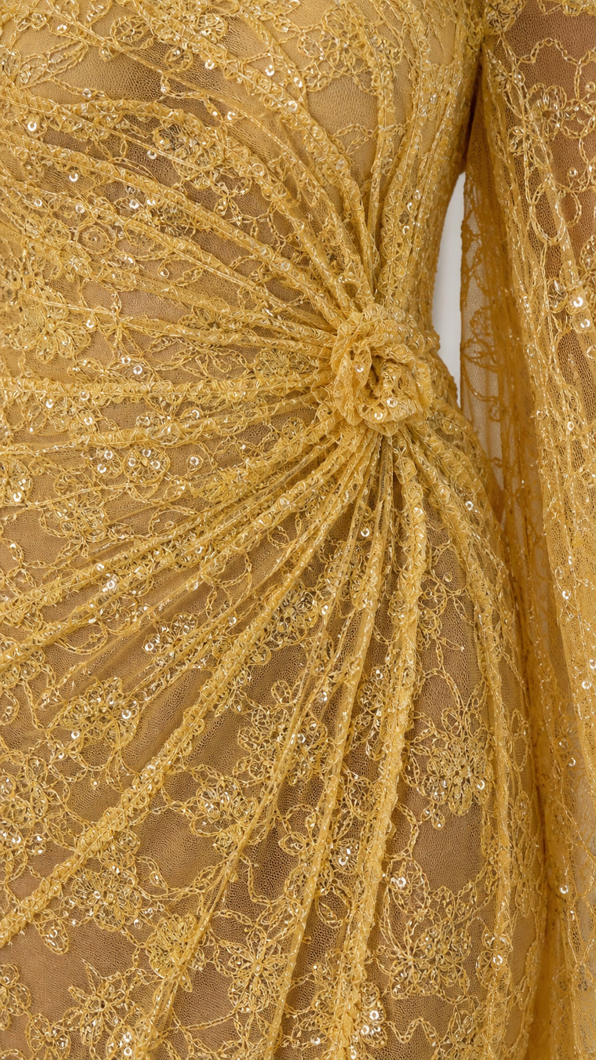 Close-up detail of textured sequin lace and waist rosette on gold gown
