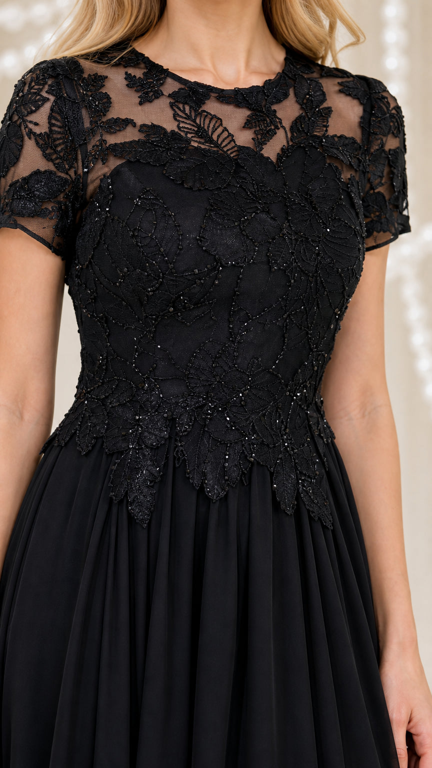 Close-up detail of lace bodice and sheer neckline on black evening dress