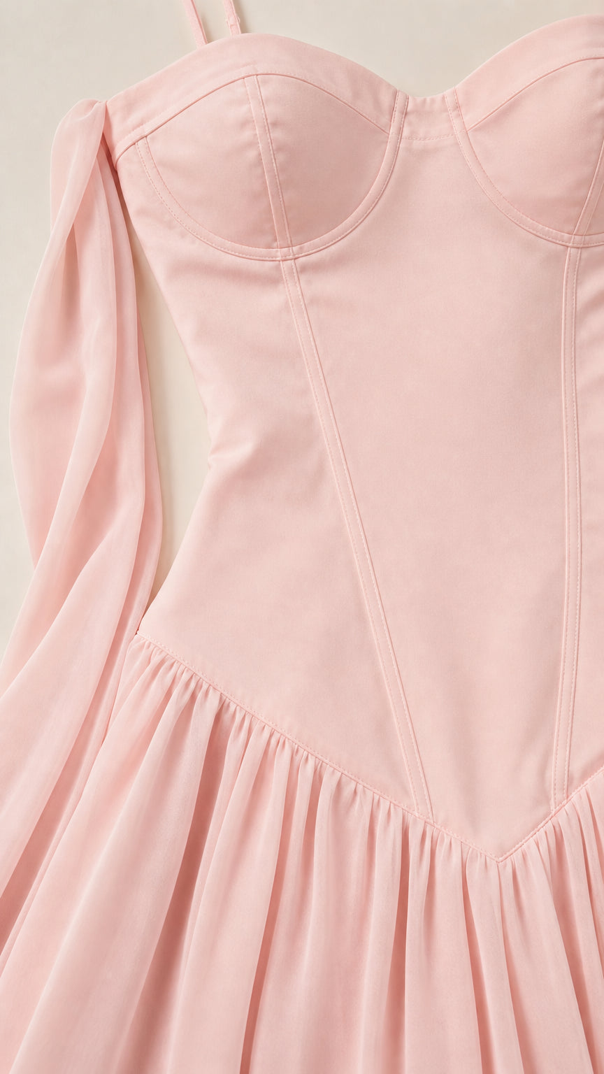 Close-up detail of structured bodice and draped sash on pink dress