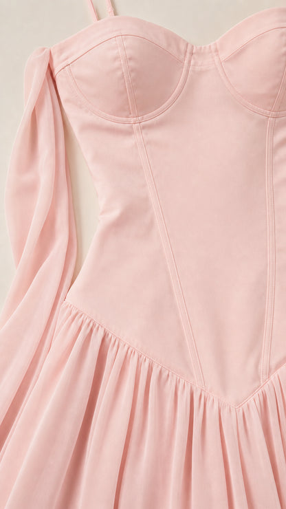 Close-up detail of structured bodice and draped sash on pink dress