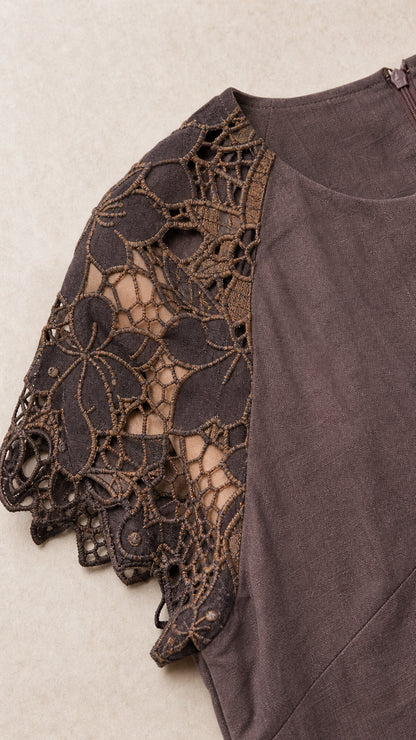 Close-up detail of openwork floral lace sleeve and fabric texture
