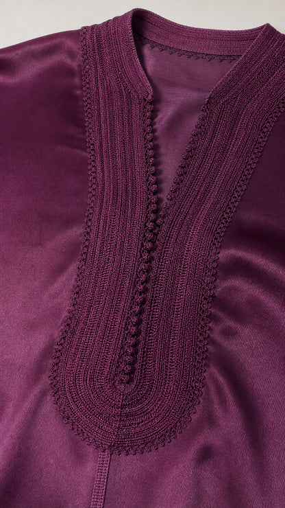 Close up detail of intricate embroidered trim on deep purple satin split neckline