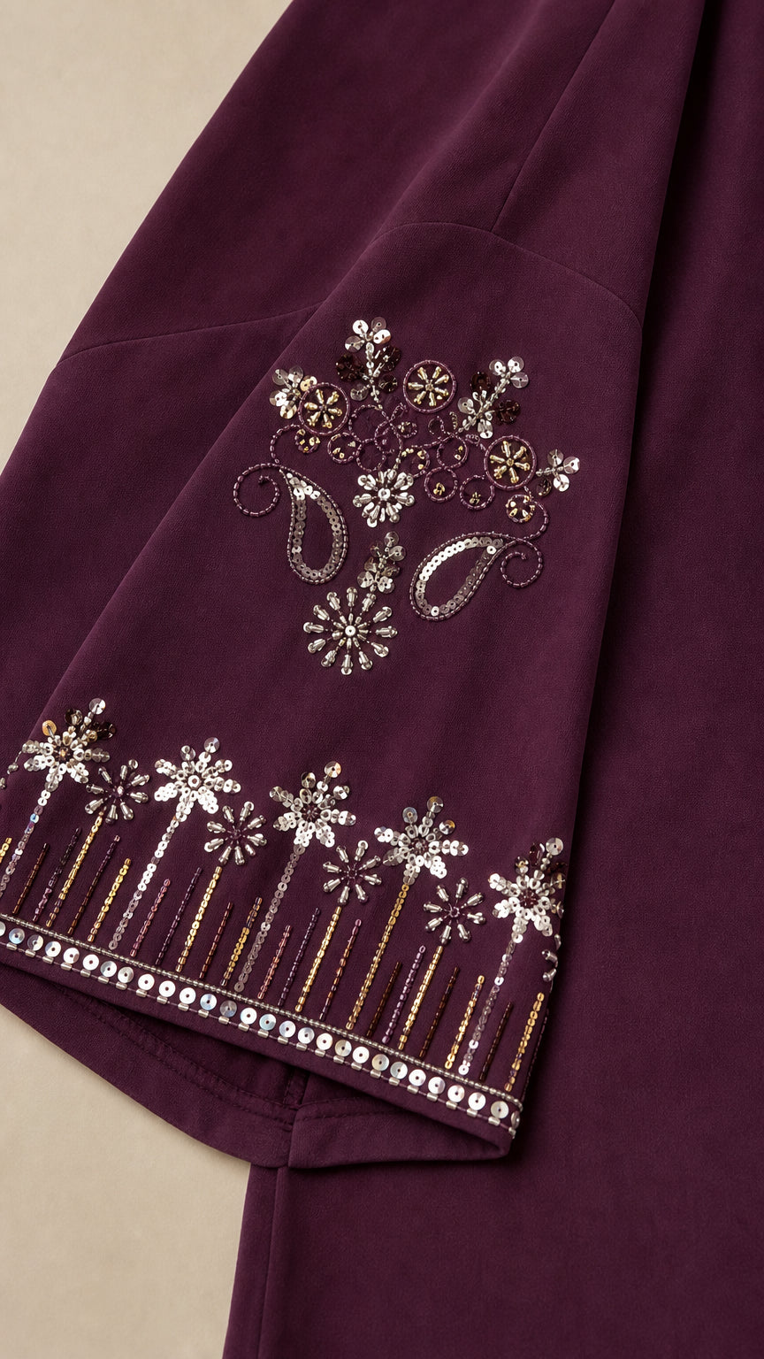 Close-up of intricate metallic thread and sequin embroidery on sleeve cuff