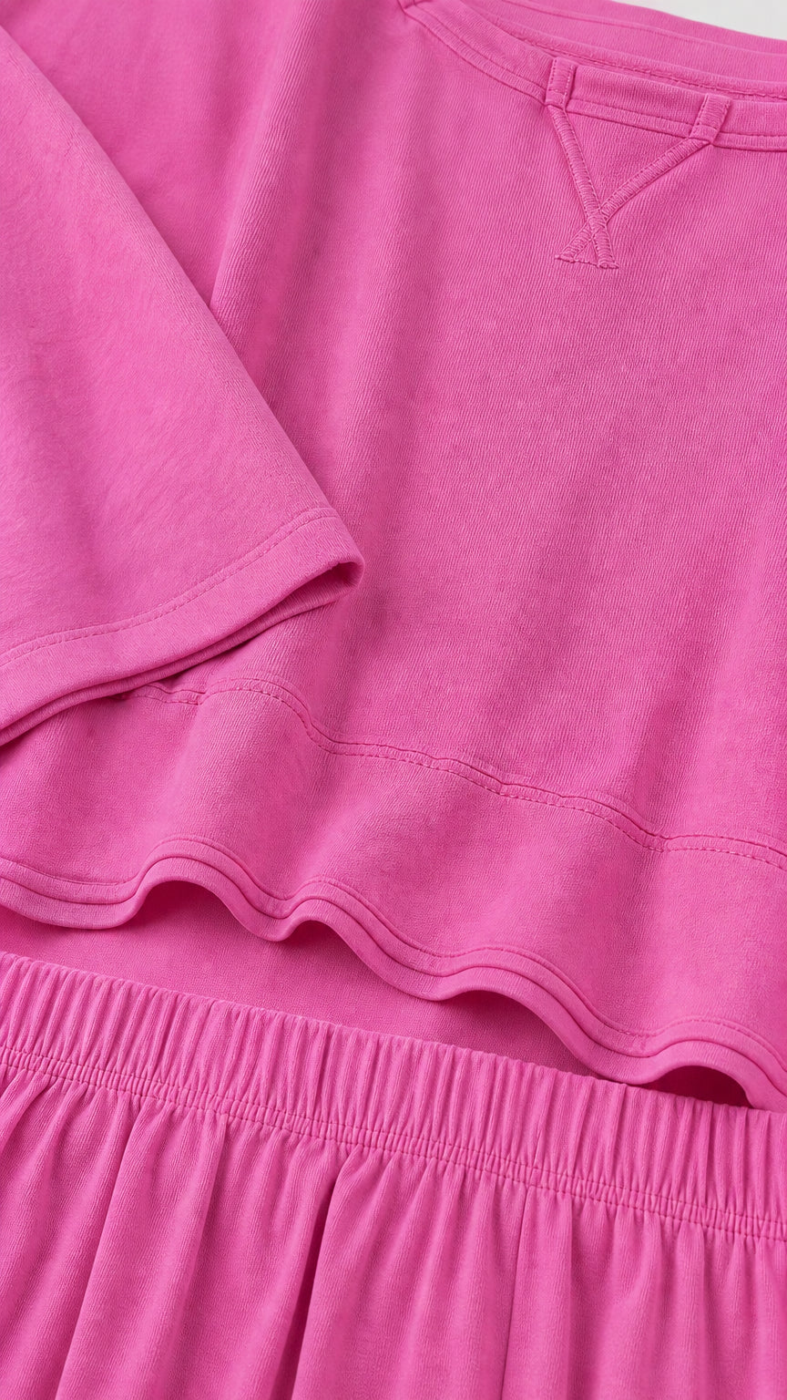Close-up detail of fuchsia knit fabric neckline and elastic waistband
