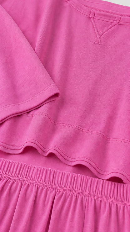 Close-up detail of fuchsia knit fabric neckline and elastic waistband