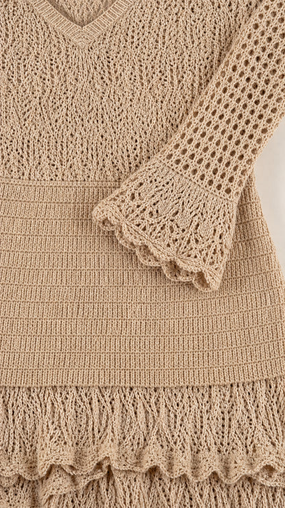 Close-up detail of crochet texture, sleeve cuff, and tiered hem