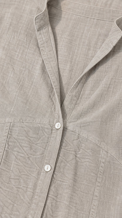 Close-up detail of grey textured fabric, buttons, and collar