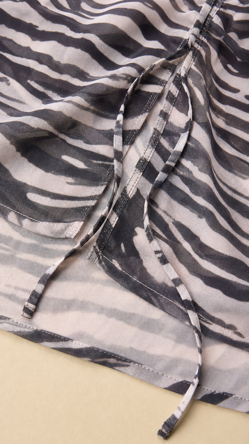 Close-up detail of side ruching and drawstring on zebra print dress