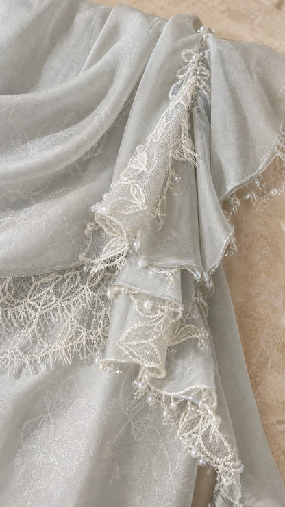 Close-up detail of lace trim, ruffles, and bead embellishments