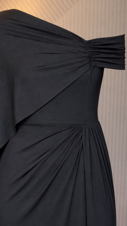Close up of shoulder drape and ruched waist on black dress