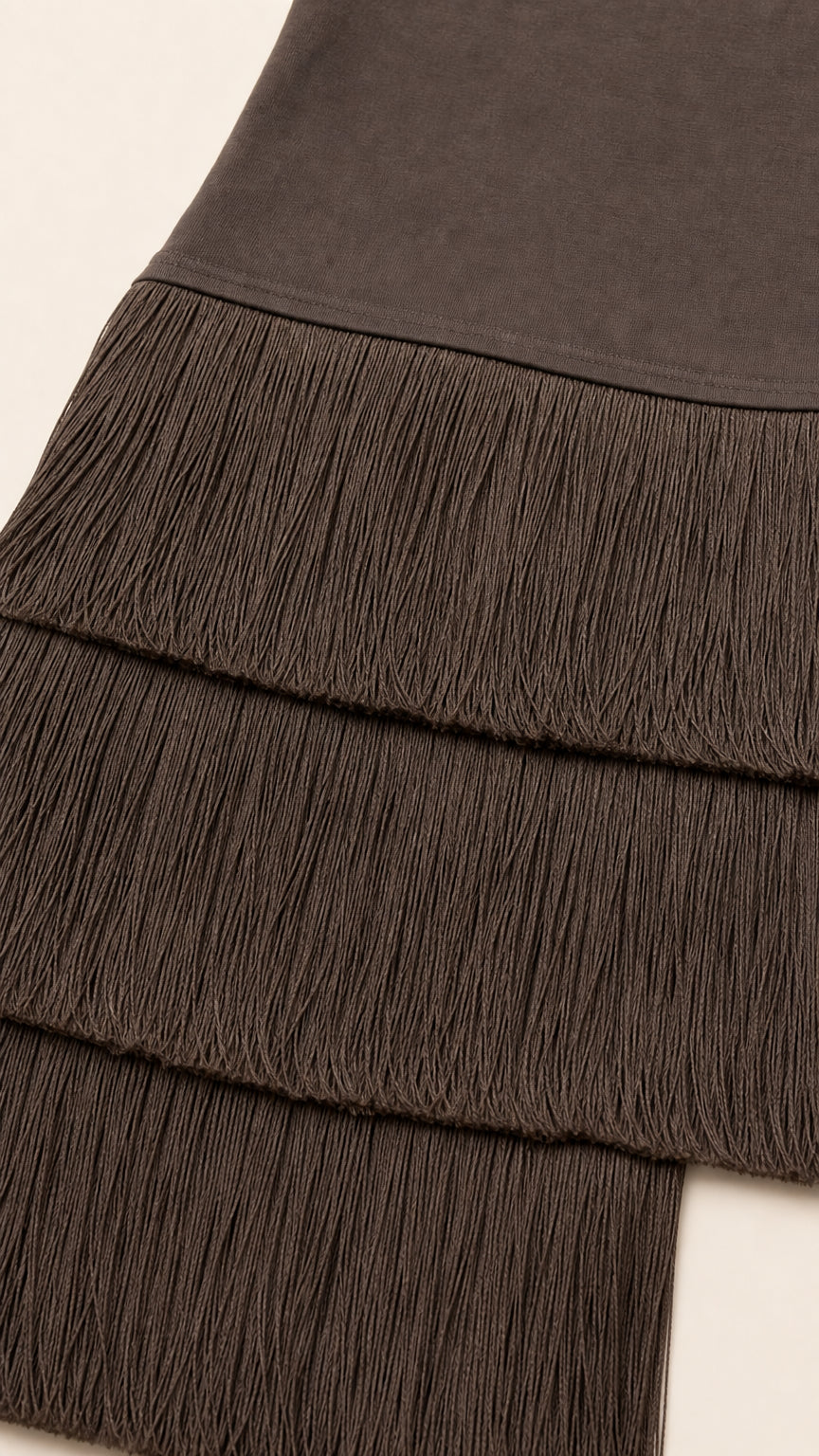 Close-up detail of mocha brown stretch fabric and layered fringe hem