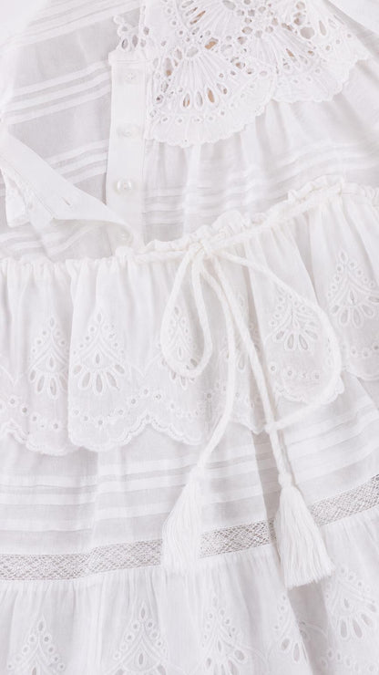 Close-up detail of eyelet embroidery and tassel drawstring on white set