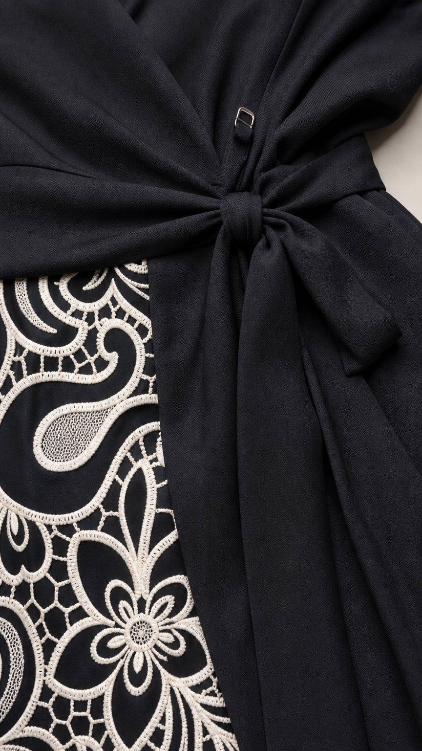 Close up of embroidery detail and tie belt on Black dress