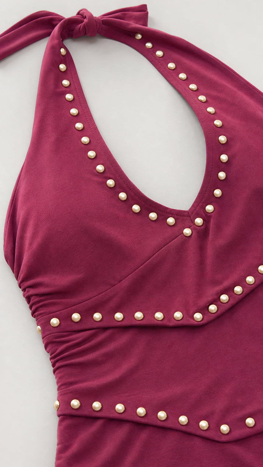 Close-up of burgundy halter neckline and stud details