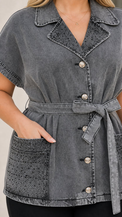Close-up detail of lapel, buttons, and pocket on grey denim tunic shirt