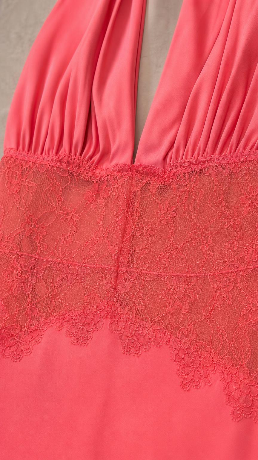 Close-up detail of lace waist panel and plunging neckline on coral dress