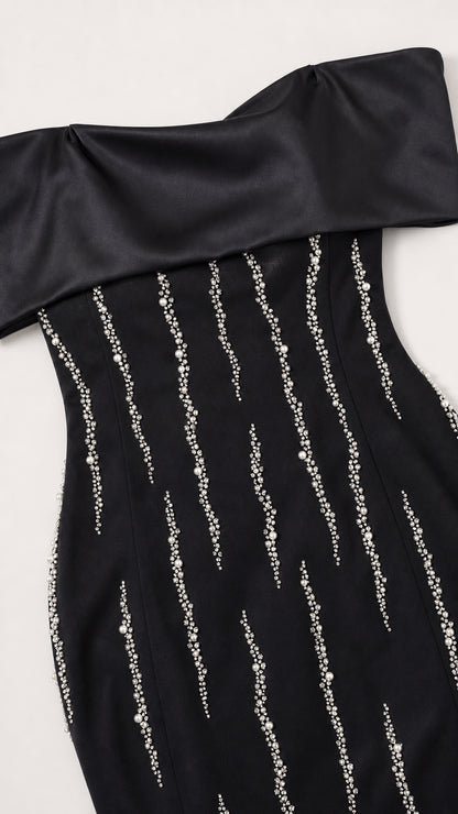 Close-up detail of black satin foldover neckline and beaded vertical accents