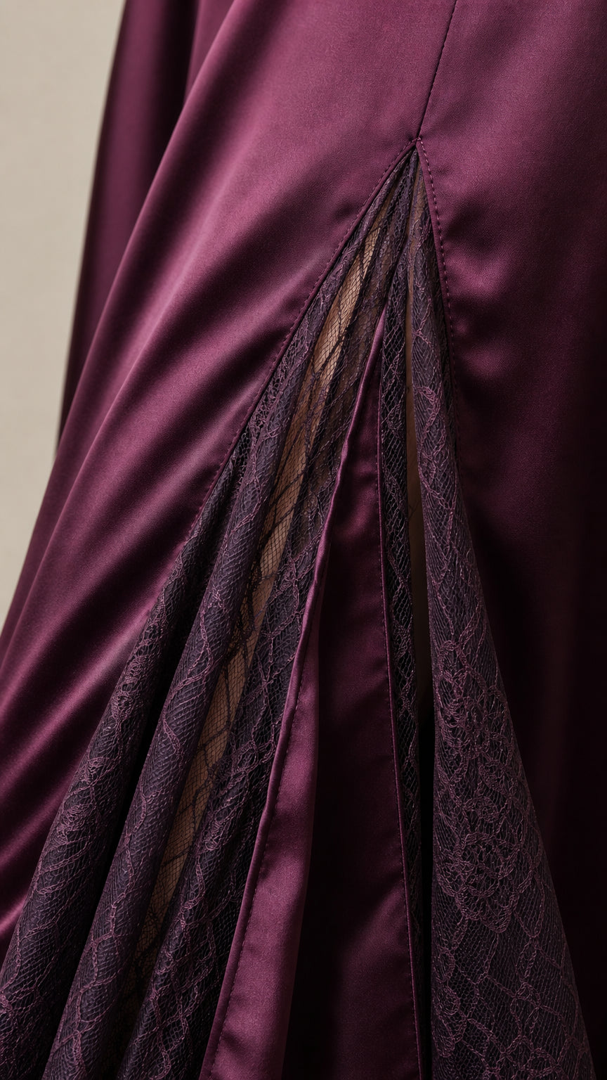 Close-up detail of sheer floral lace godet insert on satin skirt hem