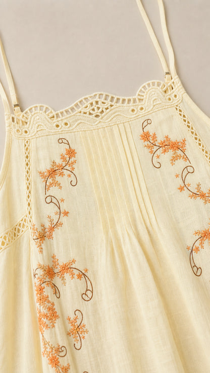 Close-up detail of yellow dress embroidery and lace neckline