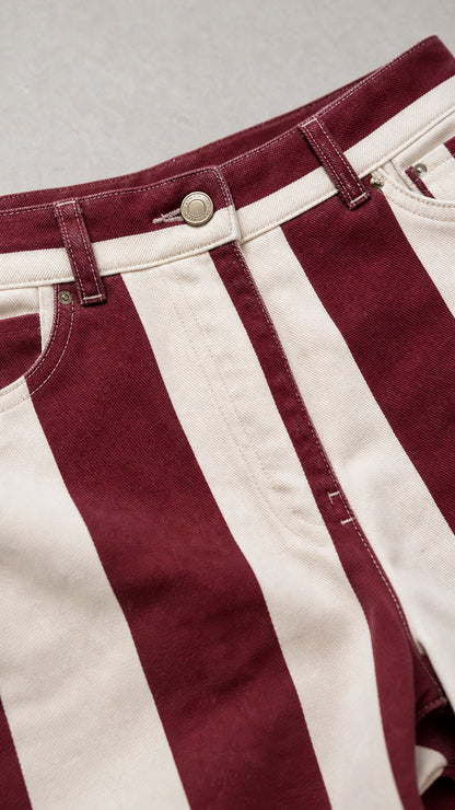 Close-up of waistband and button detail on striped trousers