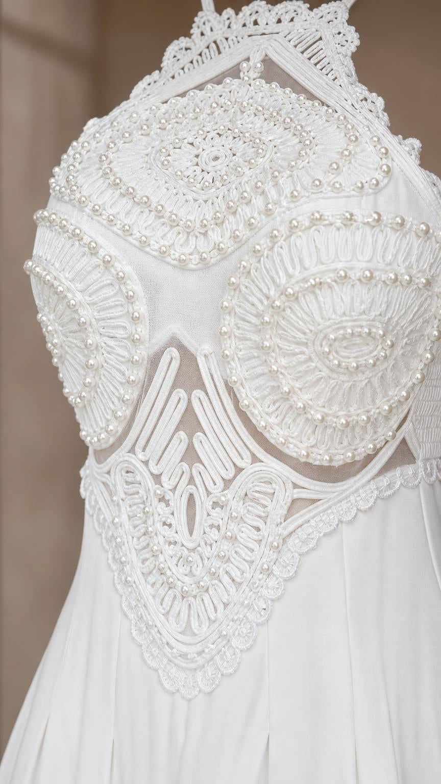 Close-up detail of ornate beaded and embroidered bodice on white dress
