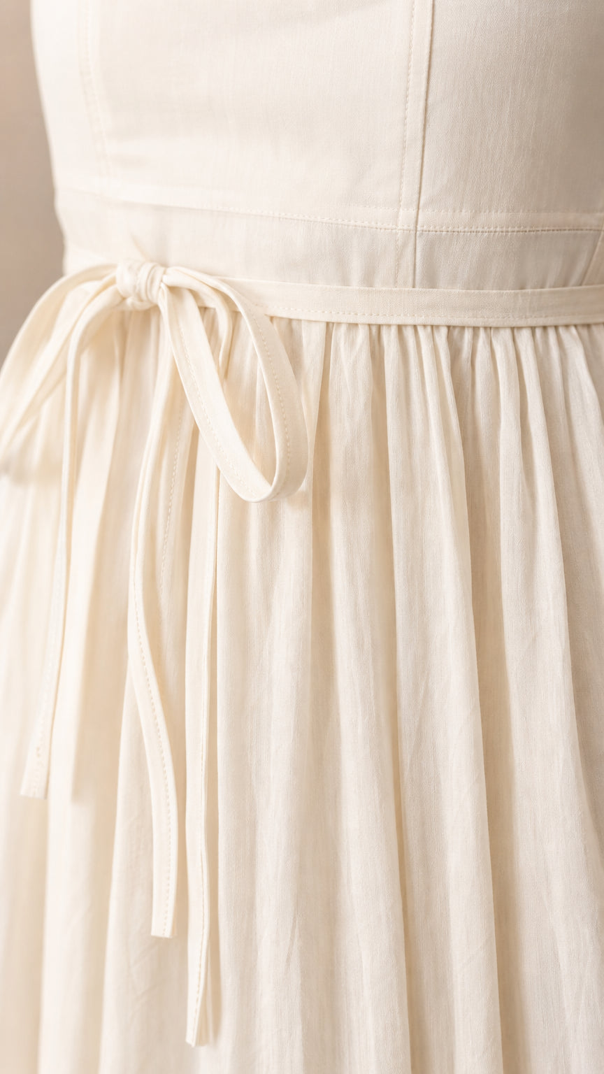 Close-up of the tie waist detail on the white maxi dress