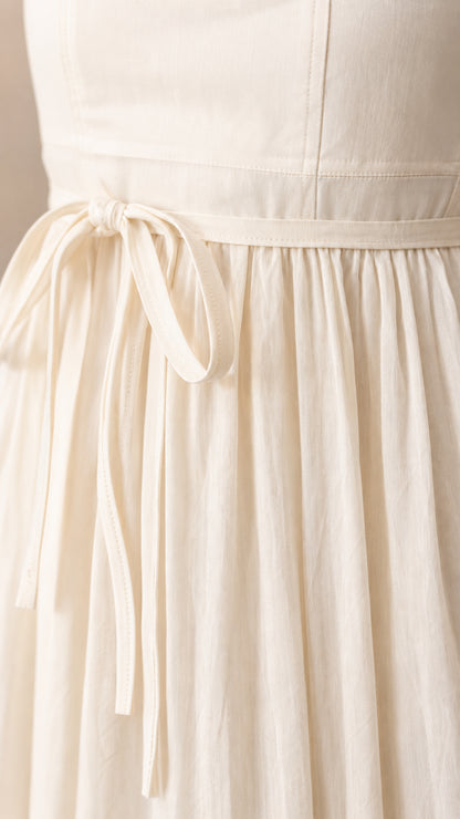 Close-up of the tie waist detail on the white maxi dress