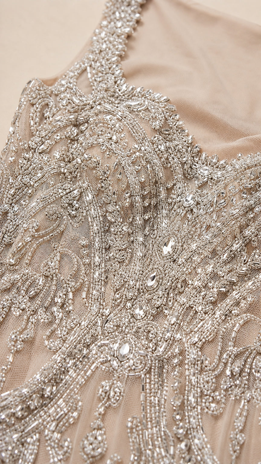 Close-up detail of intricate silver beadwork and rhinestone embroidery on mesh fabric