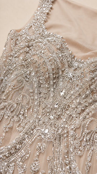 Close-up detail of intricate silver beadwork and rhinestone embroidery on mesh fabric