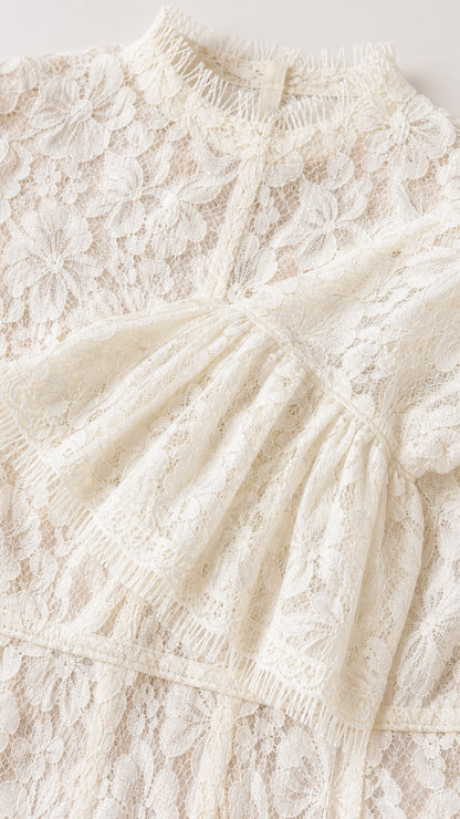 Close-up detail of white floral lace fabric and mock neckline