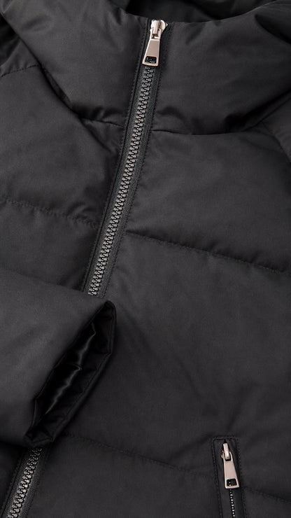 Close-up detail of smooth metallic front zipper, quilted fabric, and zippered pocket