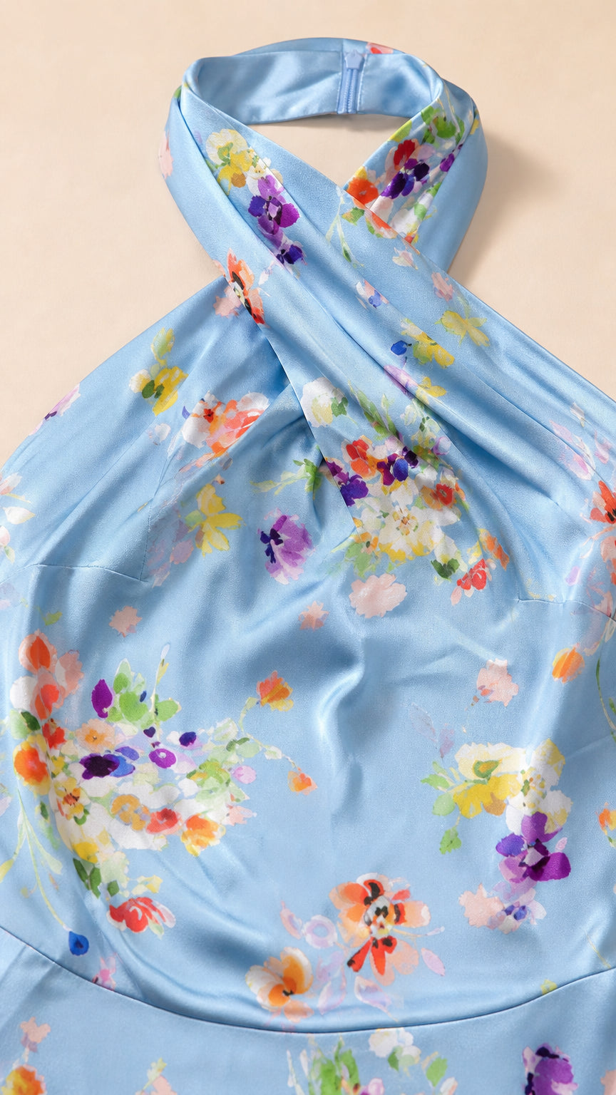 Close-up detail of crossover halter neck and floral pattern on blue dress