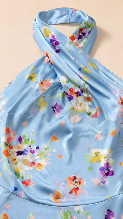 Close-up detail of crossover halter neck and floral pattern on blue dress