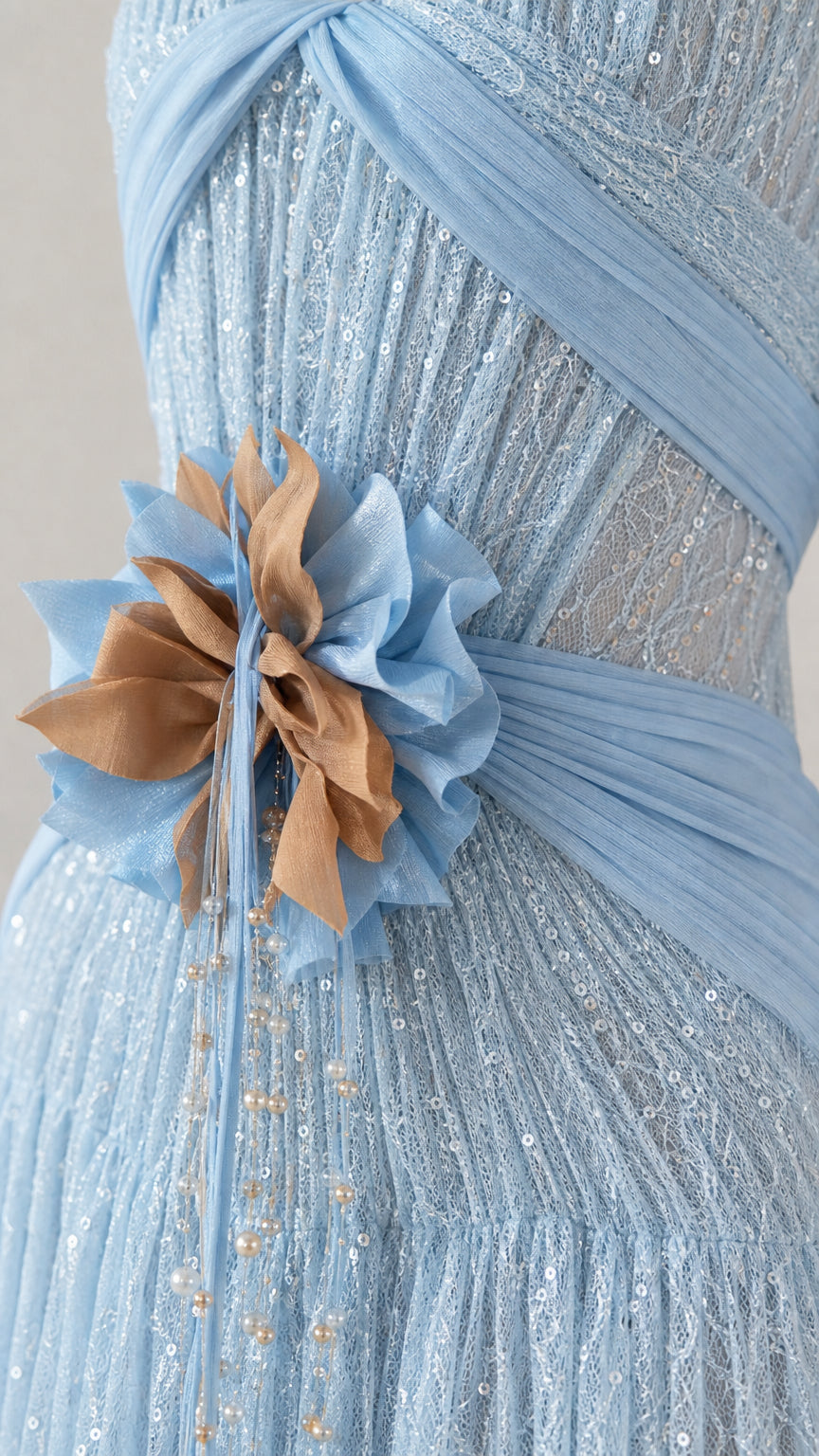 Close-up of ruched bodice, floral waist applique, and textured lace fabric