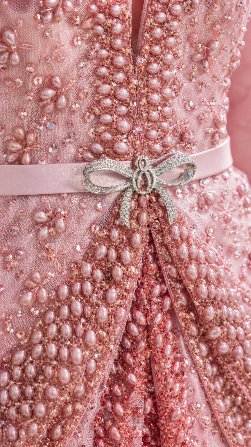 Close-up of beadwork and rhinestone bow belt on pink dress