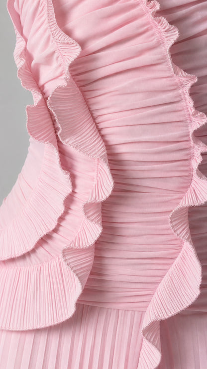 Close-up detail of accordion pleats and ruffle trim on pink dress