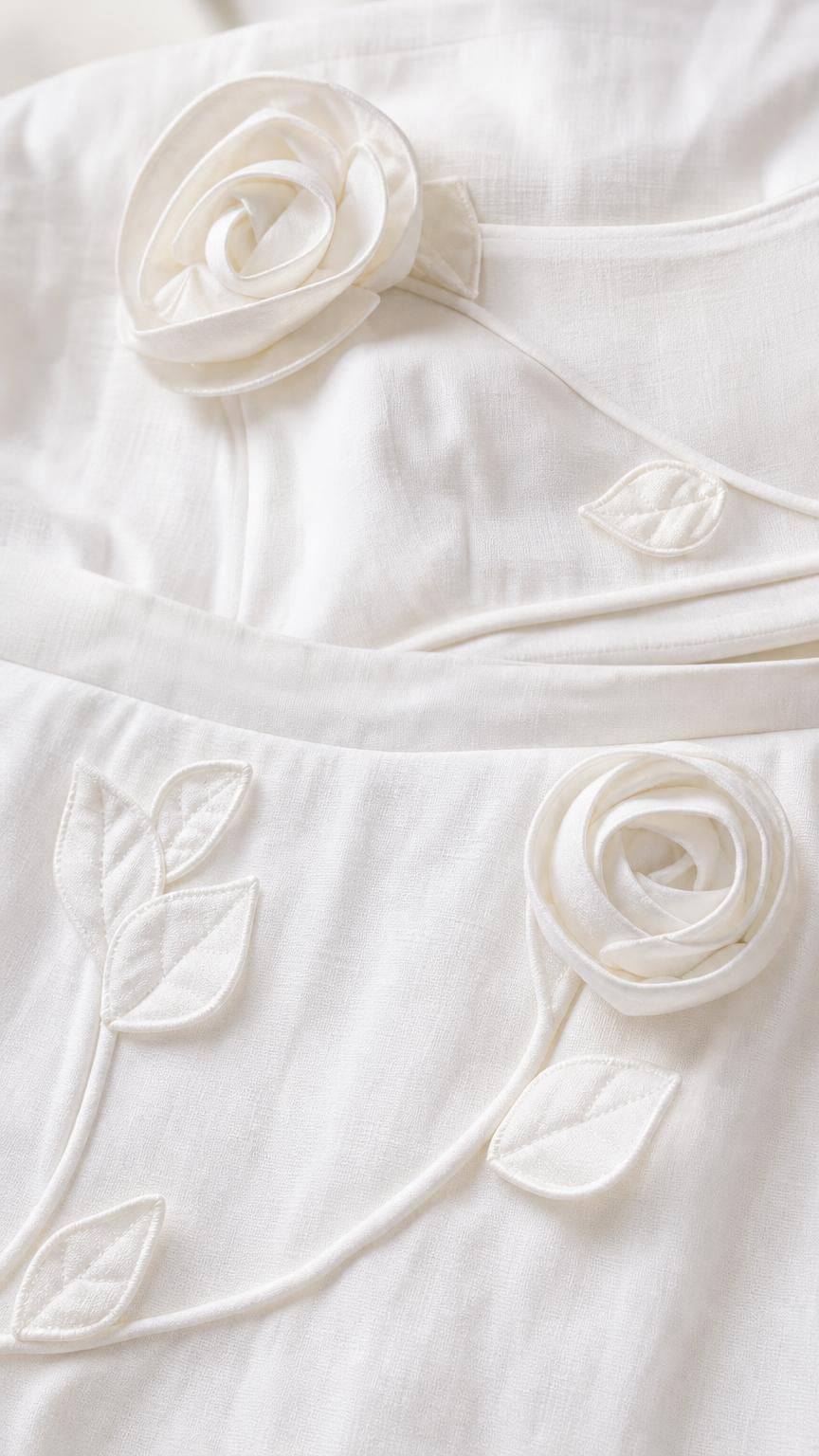 Close-up detail of 3D floral appliques and embroidery on white fabric