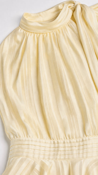 Close-up detail of high neckline and smocked waist on yellow dress