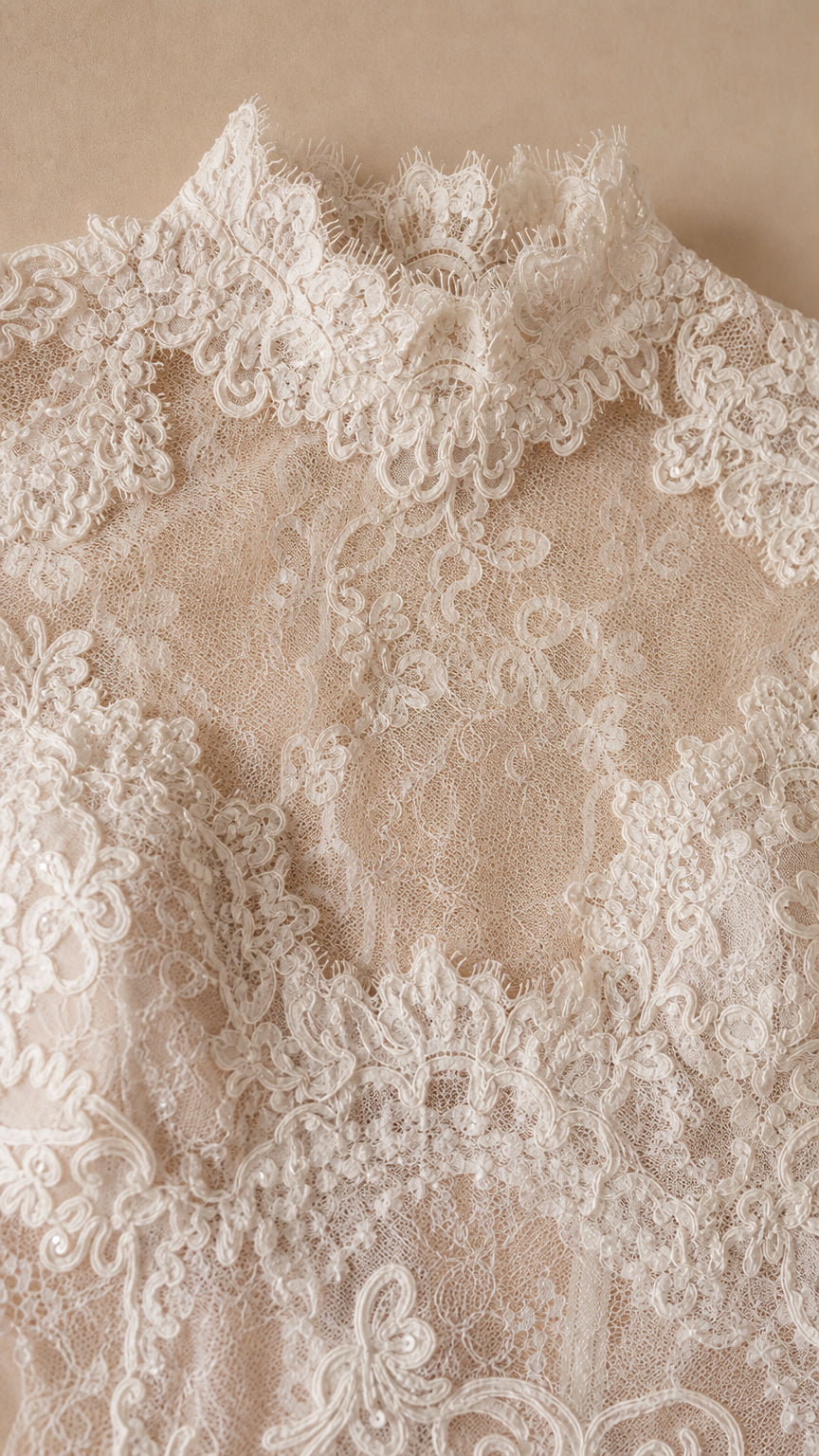 Close-up detail of textured floral lace embroidery with scalloped trim