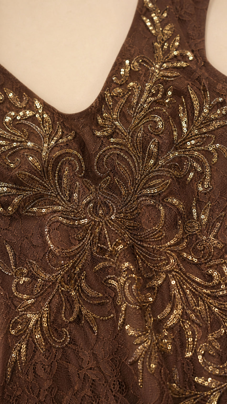 Close-up detail of gold sequin embroidery on brown lace fabric
