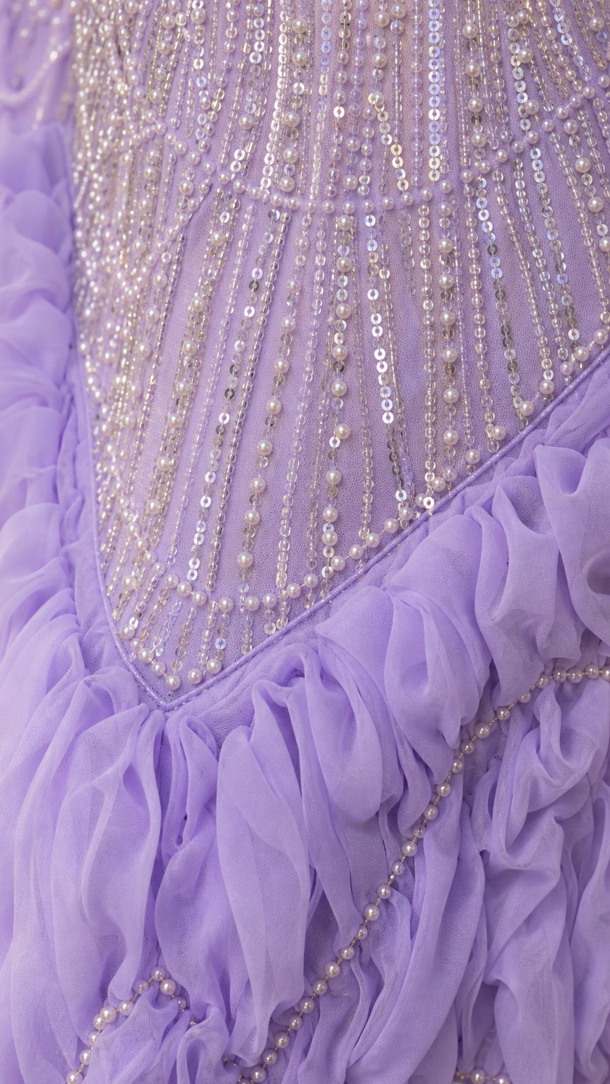Close-up detail of lavender dress showing intricate beadwork, sequins, and ruffled fabric texture